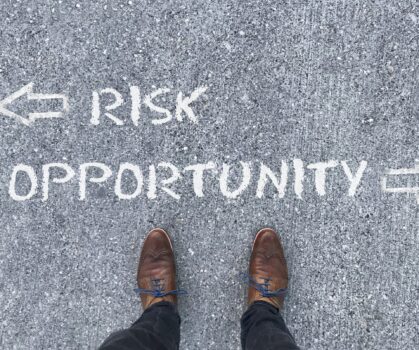 Top view on a man standing in front of the words "Risk" and "Opportunity" with arrows pointing to the left and right side of the picture