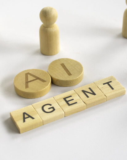 AI Agent text on wooden blocks with human figures representing artificial intelligence automation and digital workforce concept.