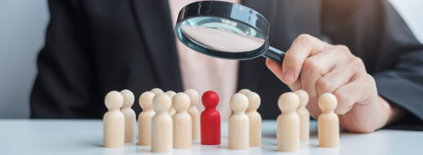 Businesswoman hand holding magnifying glass for recruiting leade Businesswoman hand holding magnifying glass for recruiting leader man wooden from crowd of employees.Human resource management, Recruitment, Teamwork, hiring and leadership Concepts